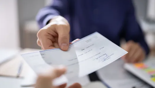 Una persona entrega un cheque