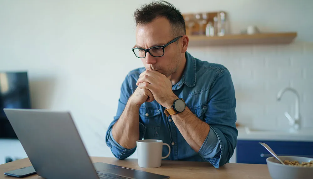 Un hombre preocupado mirando la computadora