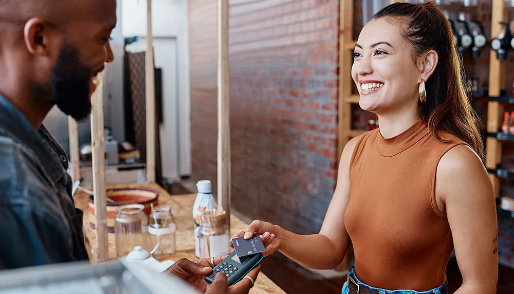 Una mujer paga comida con la tarjeta de crédito